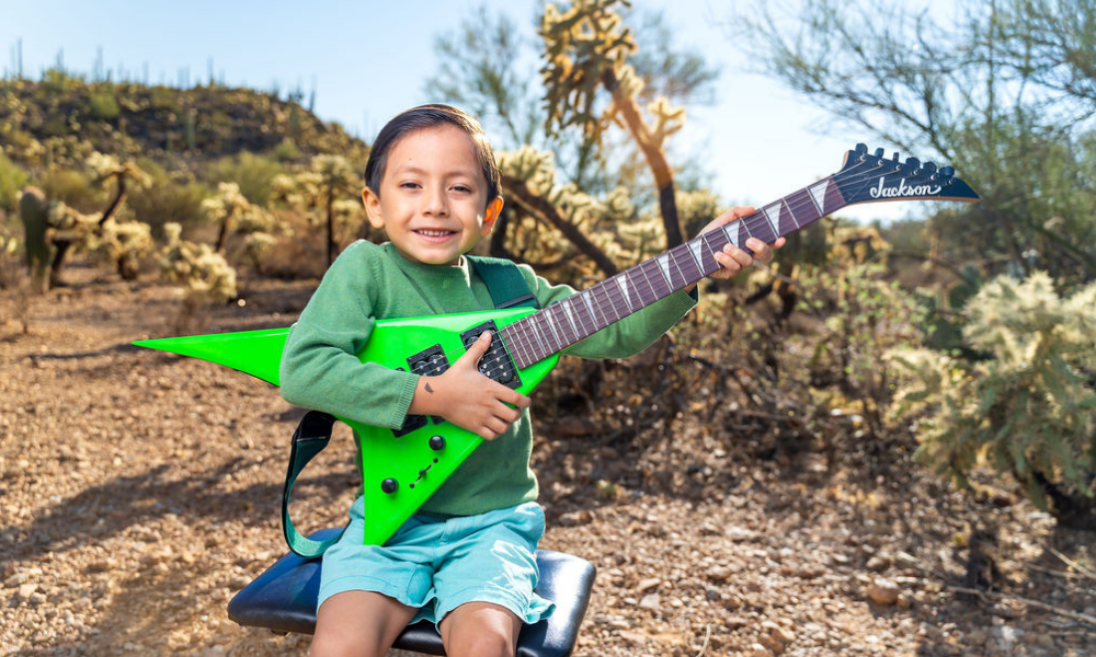 Guitar student at Allegro School of Music playing guitar in the desert.
