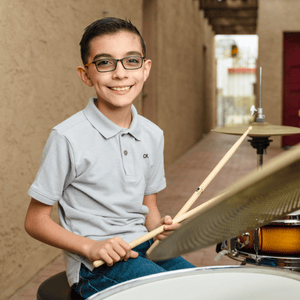 Drum student plays outside at Allegro Music and Dance foothills location in Tucson.