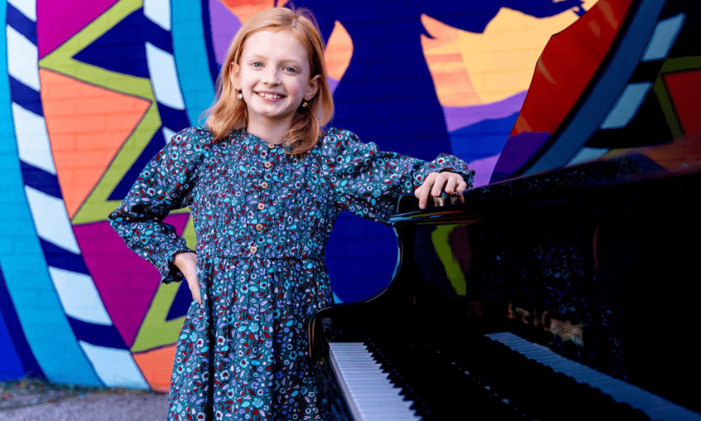 Smiling student taking piano lesson in Tucson at Allegro School of Music and Dance with supportive teacher.