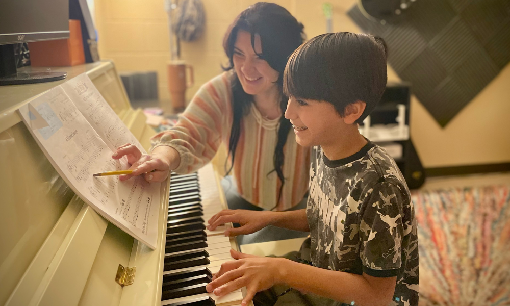 Piano teacher at Allegro Music & Dance works with happy student.